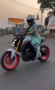 woman bike ride with saree